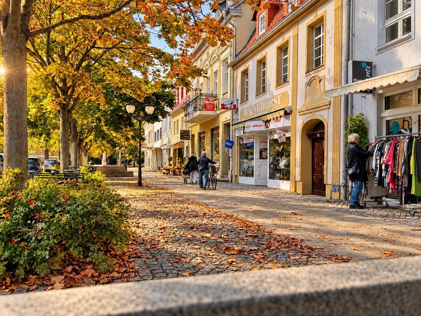 Die Breite Straße in Lübben mit Herbstlaub und Bäumen