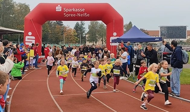 Kinder laufen beim Bambinilauf durch das Leichtathletikstadion