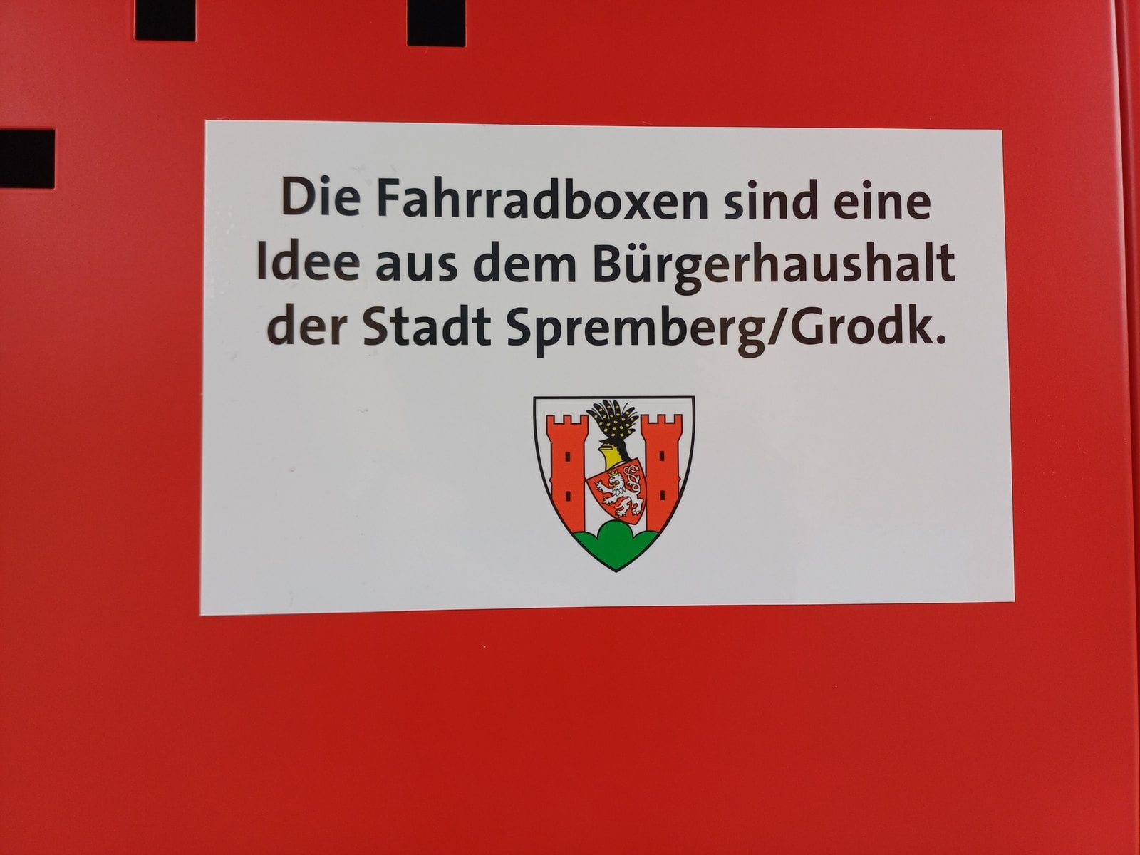 Schild an den Fahrradboxen mit Hinweis auf den Bürgerhaushalt der Stadt Spremberg/Grodk