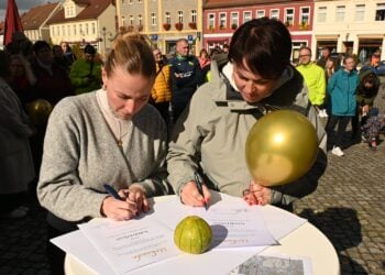 Sternenkinderlauf in Lübbenau: Amy Kullick und Katrin Erbert unterzeichnen auf dem Kirchplatz eine Urkunde
