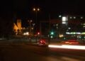 Nahezu leere Kreuzung am Bahnhof Cottbus bei Nacht mit Straßenlaternen und Lichtspuren eines Autos