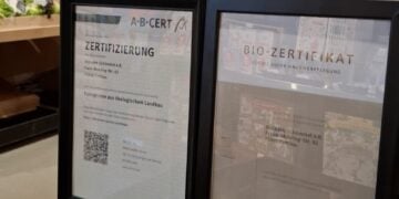 Gerahmte Bio-Zertifikate im Bioladen Schömmel in Cottbus, dahinter Regale mit Obst und Gemüse