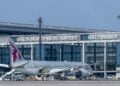 Ein Dreamliner von Qatar Airways steht vor dem Terminal 1 mit dem Schriftzug Berlin Brandenburg Airport Willy Brandt