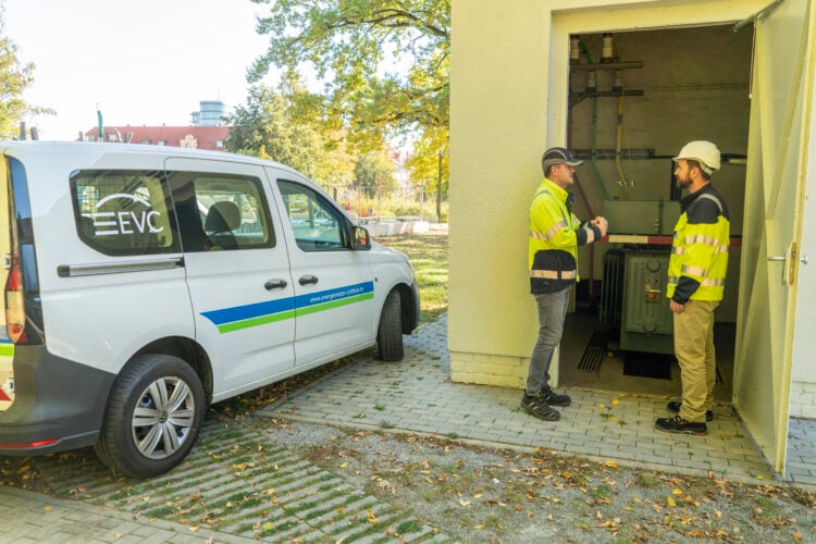 Zwei Mitarbeiter der Elektroenergieversorgung Cottbus an einer Trafostation, daneben ein EVC-Fahrzeug