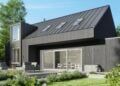 Modernes Einfamilienhaus mit dunkler Holzfassade, Dachfenstern und großer Schiebetür zur Terrasse