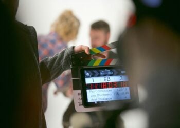 Eine Person hält bei Dreharbeiten eine Filmklappe in die Kamera