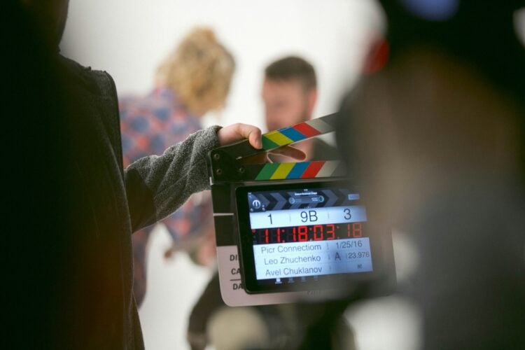 Eine Person hält bei Dreharbeiten eine Filmklappe in die Kamera