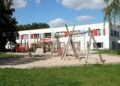 Betreuungsstufe Symbolbild: leerer Spielplatz mit Holzgerüsten vor einem Kita-Gebäude in Königs Wusterhausen