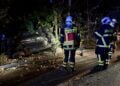 Feuerwehrleute an dem auf der Seite liegenden Unfallwagen in Bohrau