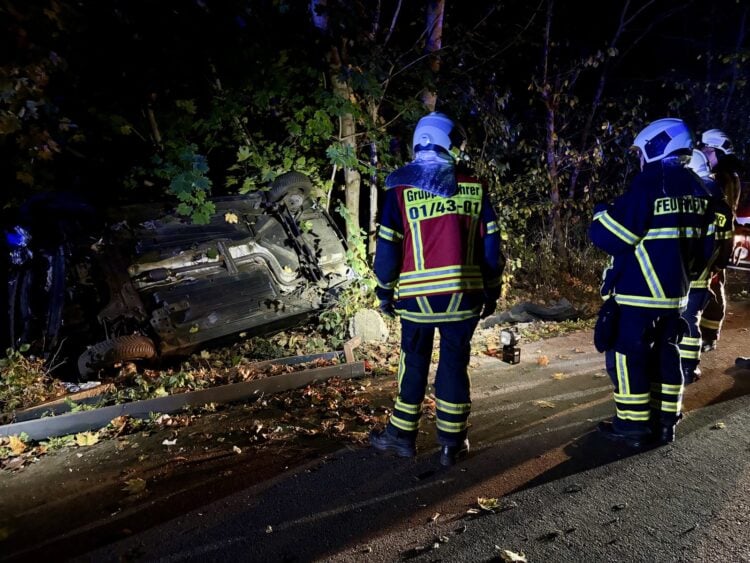 Feuerwehrleute an dem auf der Seite liegenden Unfallwagen in Bohrau
