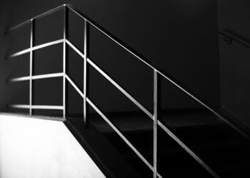 Schwarz-Weiß-Aufnahme einer Treppe mit schlichtem Stahlgeländer
